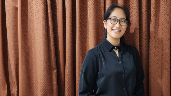 Saranya  standing in front of redish curtains