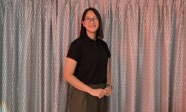 Saranya  standing in front of redish curtains